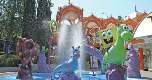 Zona infantil Nickelodeon Land en el Parque de Atracciones de Madrid, con niños disfrutando de atracciones temáticas de Bob Esponja y otros personajes.