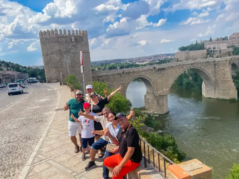 Nuestros clientes comparten una foto junto al río, con un puente centenario que enmarca su experiencia en el tour.