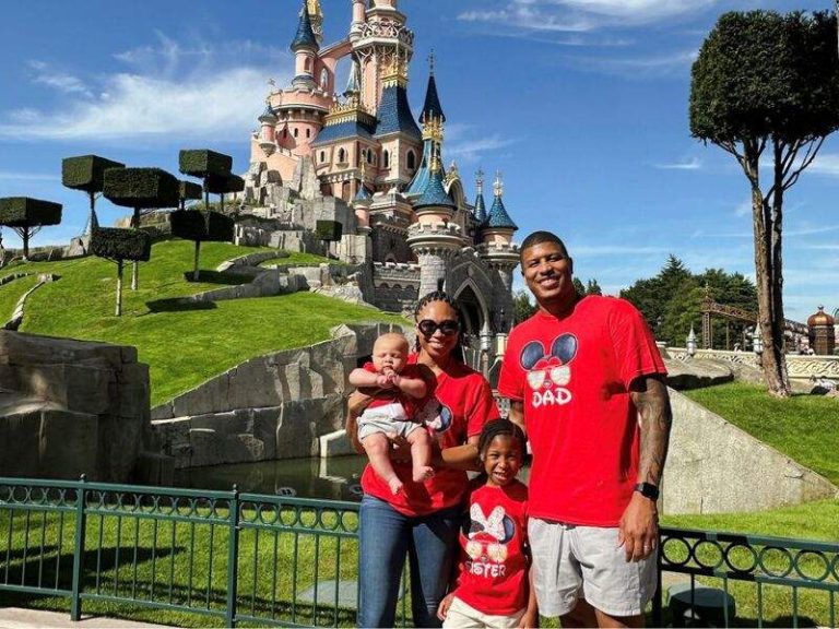 familia de 4 personas felices frente al castillo de disneyland parís