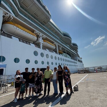 una foto de una familia durante unas vacaciones en crucero por el caribe. son clientes de la agencia de viaje g-travel. foto compartida por Viviana Rivera Jimenez. 2026 de fondo de ve el barco del crucero y el sol