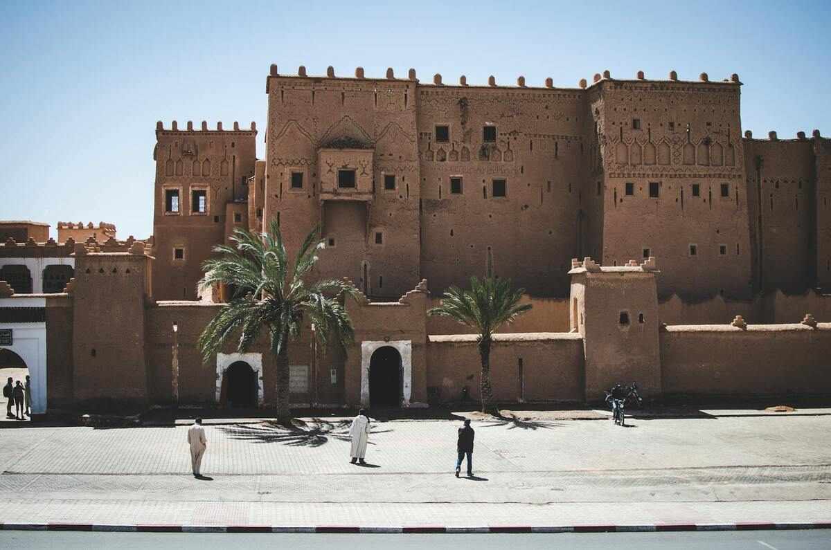 Arquitectura tradicional de adobe y tonos tierra en Ouarzazate, Marruecos, mostrando la estructura geométrica de una Kasbah bajo la luz cálida del desierto.