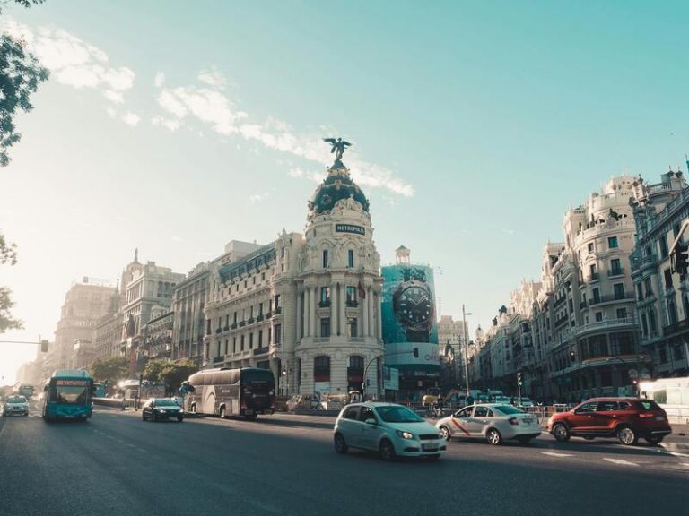 Coches En La Carretera Cerca De Edificios en Madrid Capital, España. Se usa para ejemplifica un Traslado en Madrid.