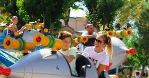 Un hijo y su madre disfrutando de una atracción infantil en forma de cohete en el Parque Warner Madrid de España.