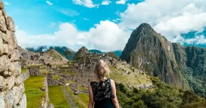 Mujer admirando la vista de Machu Picchu, el sitio arqueológico más icónico del Perú.