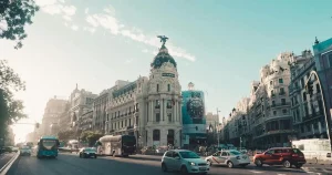 Coches En La Carretera Cerca De Edificios en Madrid Capital, España. Se usa para ejemplifica un Traslado en Madrid.